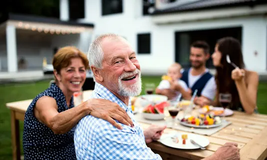 Haus-Familie-Wohnen-Garten-Serie-30-01 Großeltern und deren Kinder im Garten eines Mehrgenerationenhaus